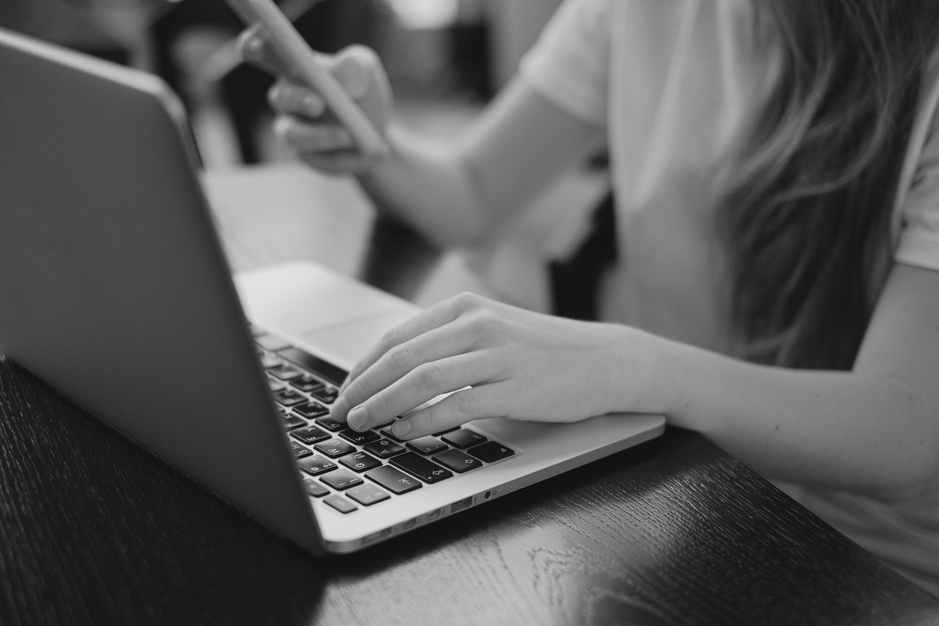 A Person in White Shirt Using a Laptop